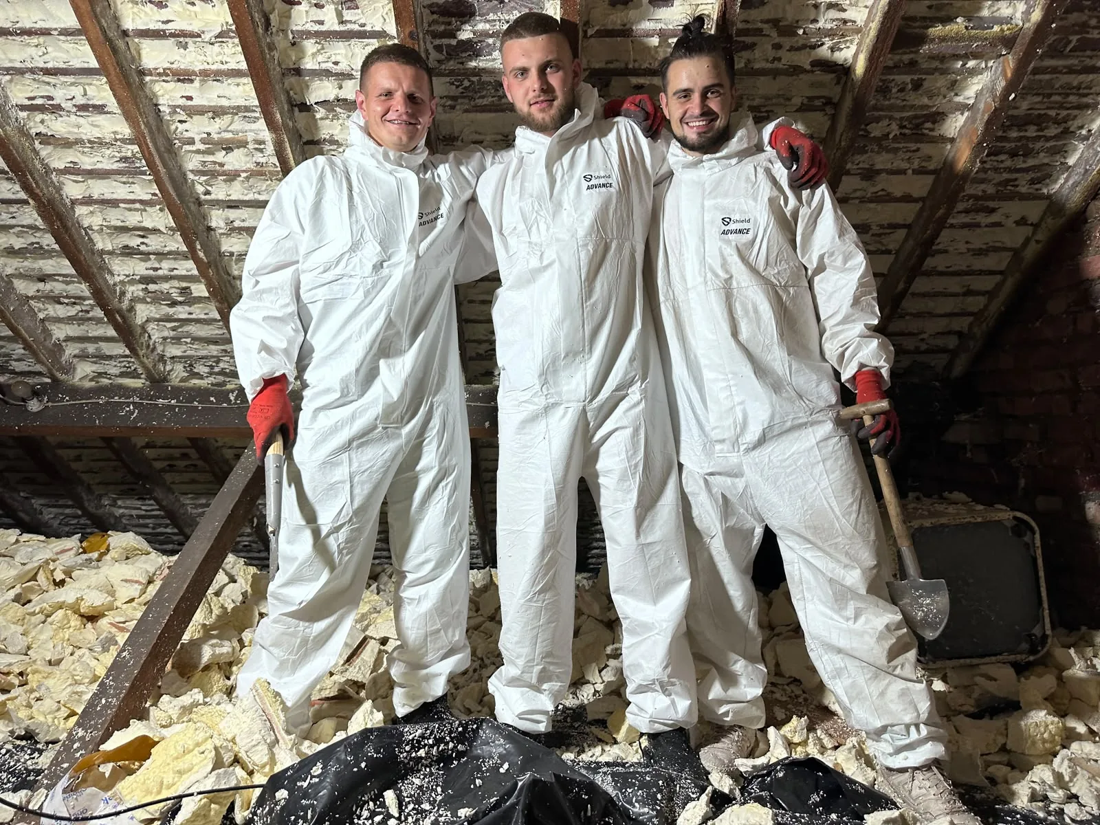 The Apex team in coveralls and gloves inside a loft